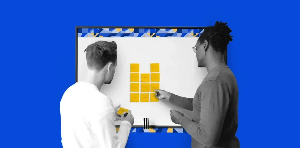 Two people in front of a whiteboard with sticky notes arranging a task or workflow, against a blue background with geometric design elements.