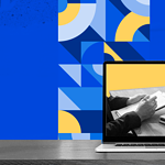 The image features a laptop displaying a photo of two people in a business meeting, set against a patterned blue background with geometric designs and a white atomic symbol floating above the laptop.