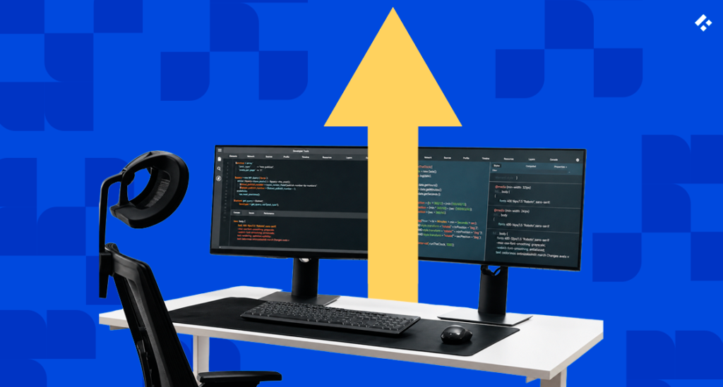 Desk with dual monitors showing code and an upward arrow, representing how to ramp up augmented engineers on a regulated codebase