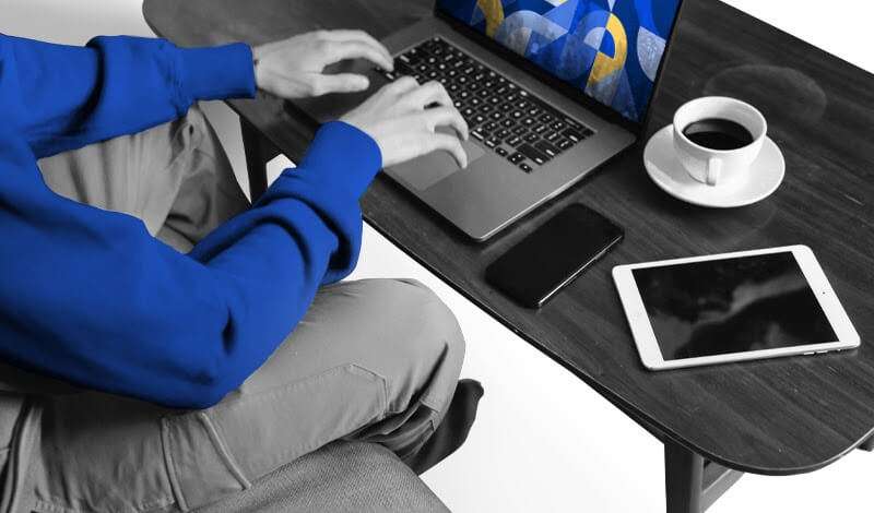 Woman sitting with laptop on abstract colorful background with geometric shapes and programming symbols.